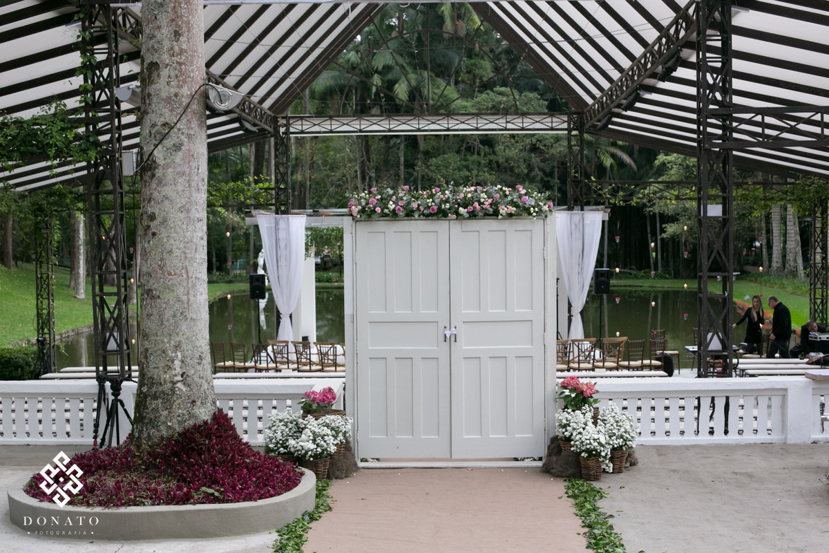 Decoração Fazenda 7 Lagoas, com porta de madeira branca e flores lindas.