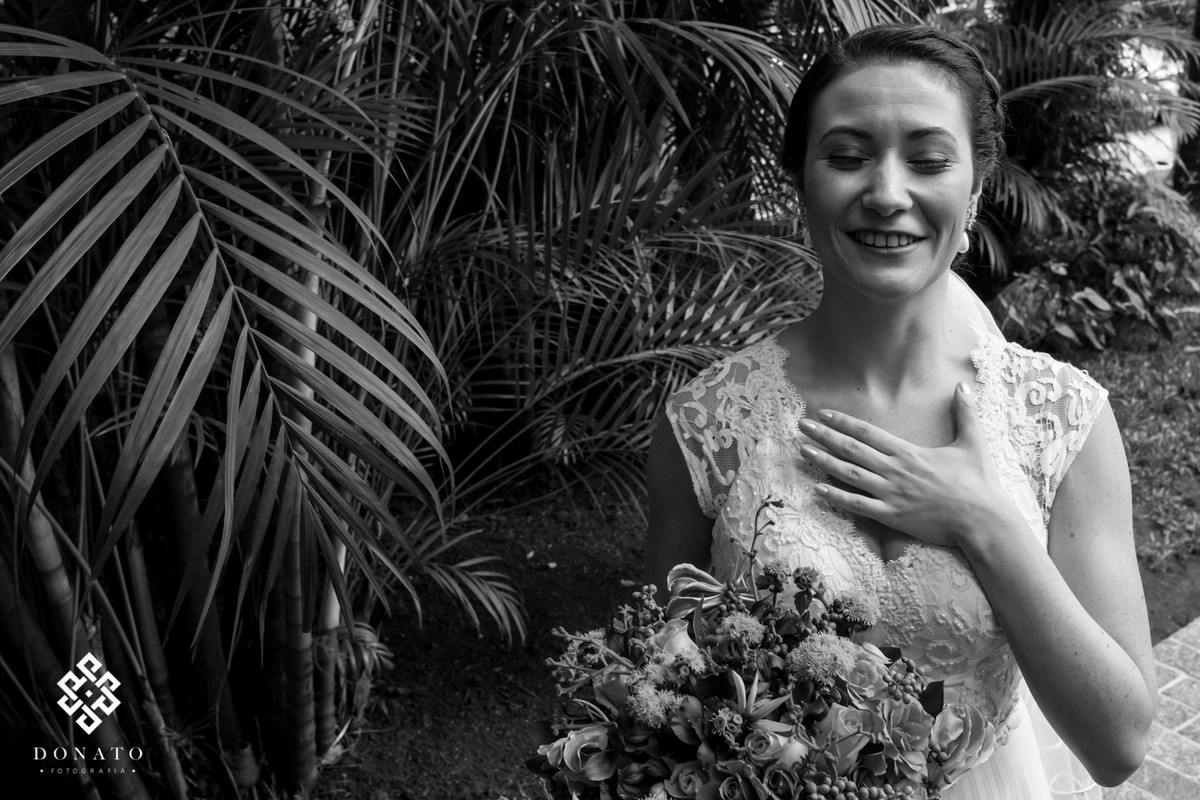 Noiva esta preparada para o casamento e coloca a mão no peito muito emocionada.