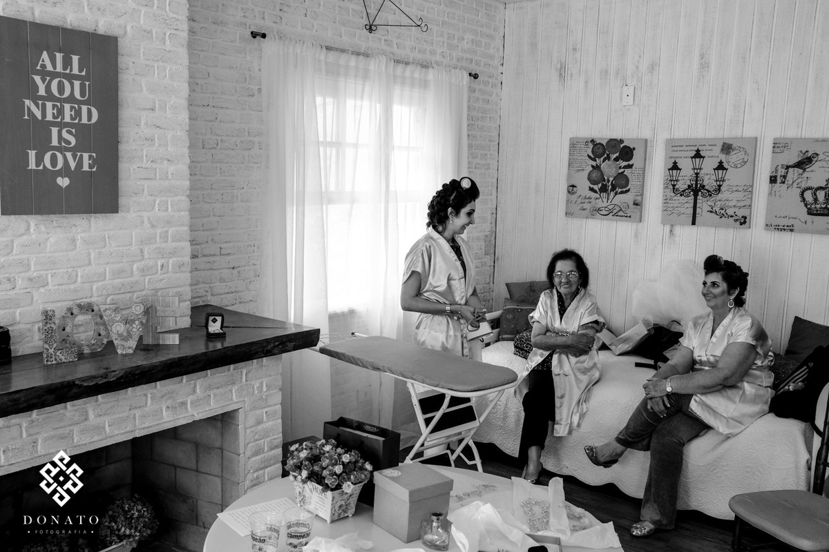 Noiva passando a roupa no dia do seu casamento.