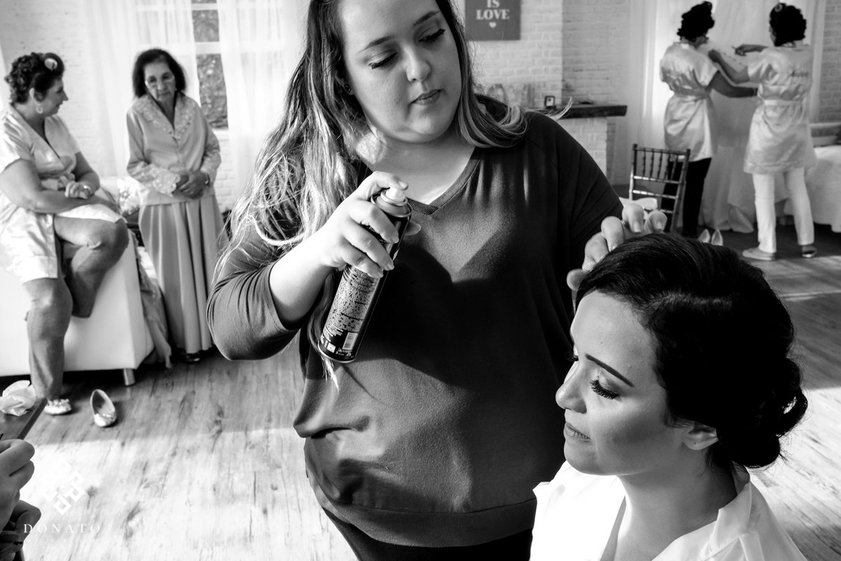 a maquiadora Tassya Lopes, finaliza o cabelo e a maquiagem da noiva.
