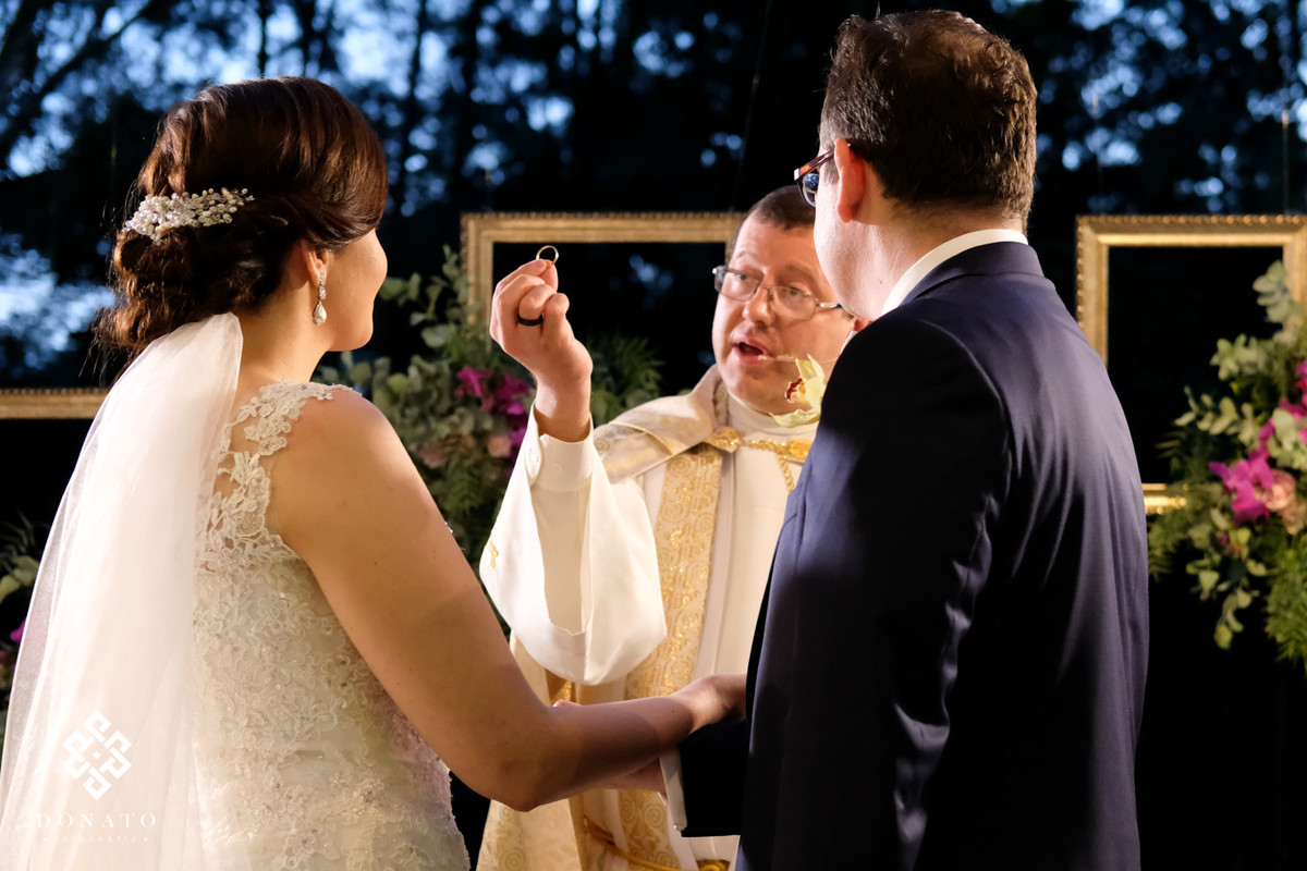 Padre segura aliança nas mãos.