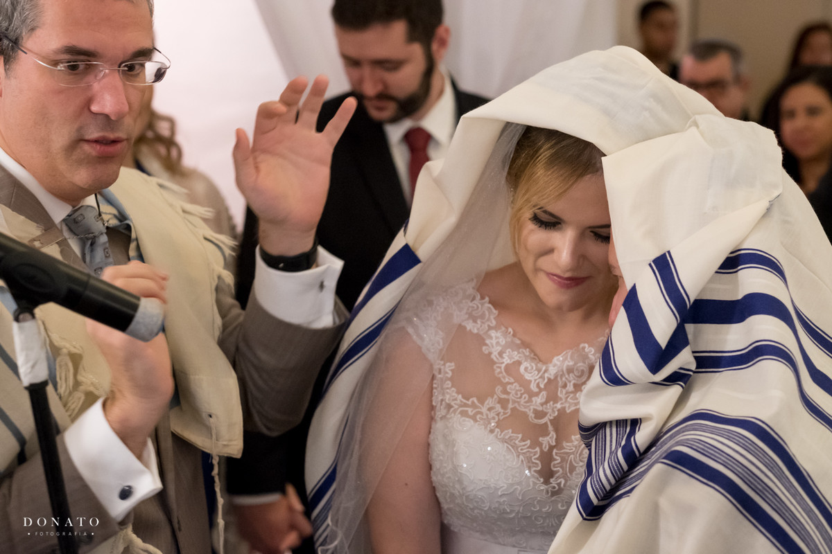 Noivos são coberto em um dos rituais da cerimonia judaica.