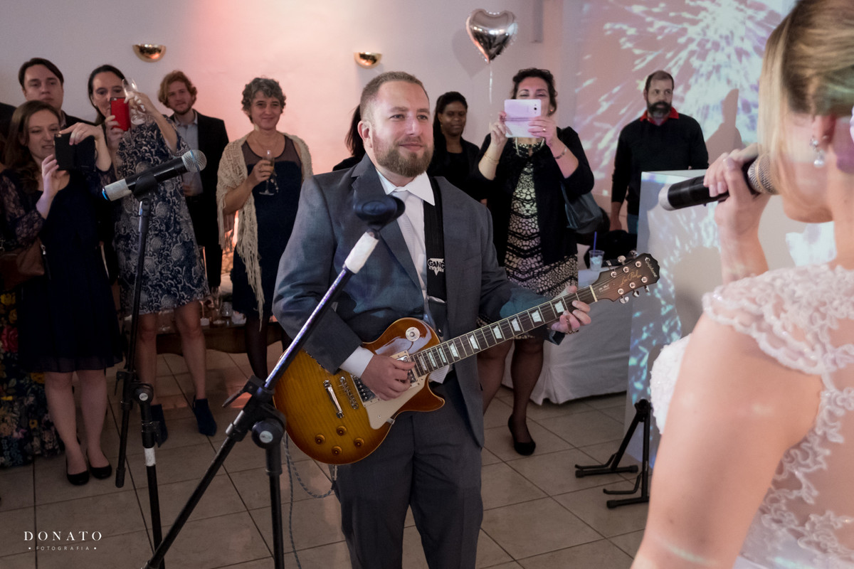 Noivo tocando sua guitarra na festa.