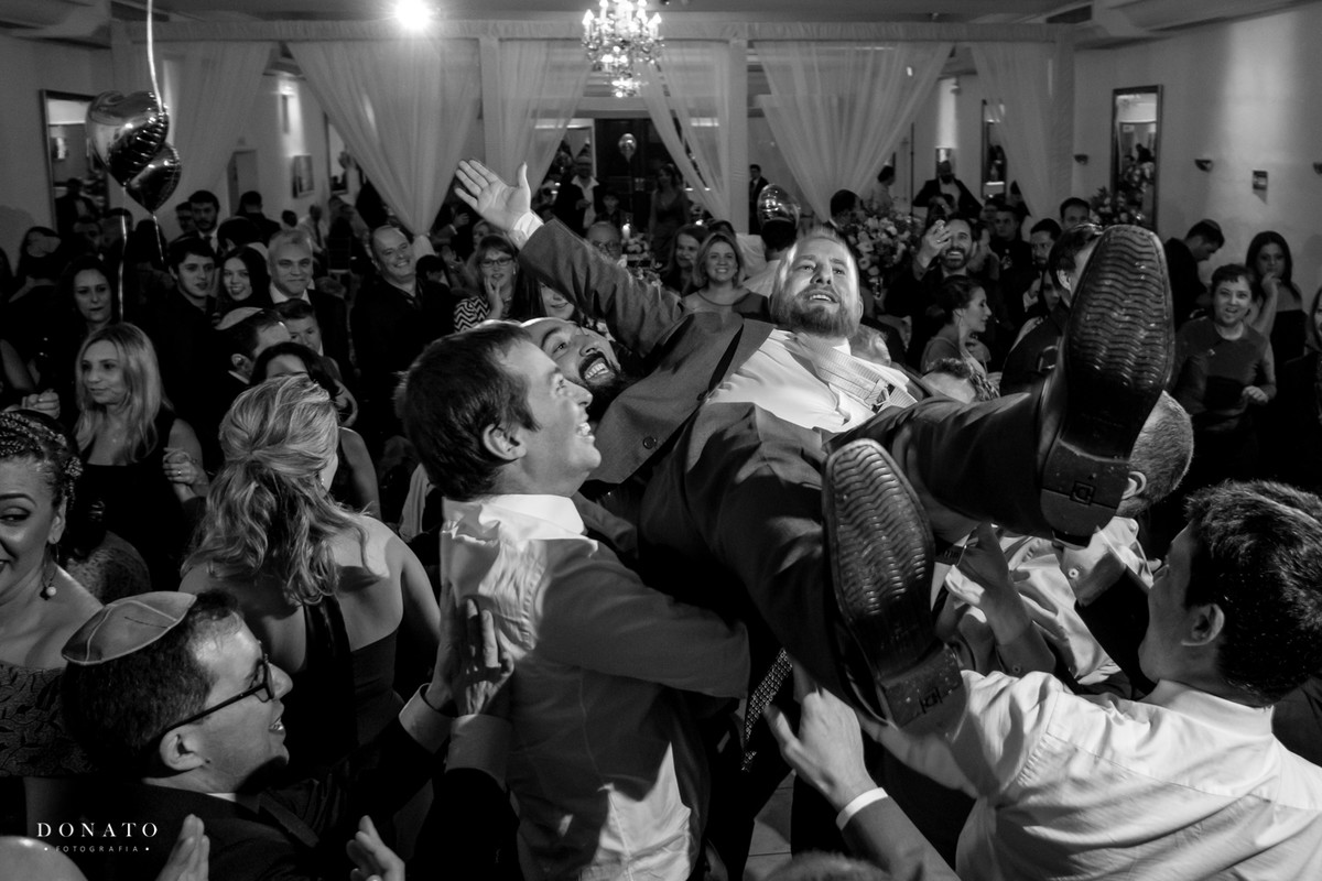 Noivo é jogado pra cima pelos padrinhos e amigos.