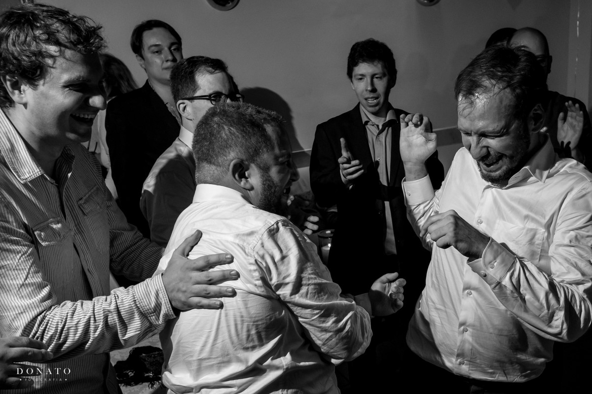 Amigos agarram e batem carinhosamento no noivo em um dos rituais do casamento judeu.