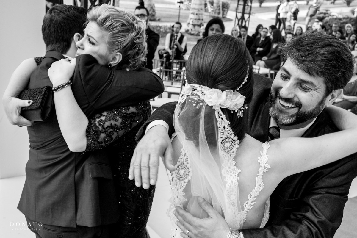 pais abraçam a noiva.