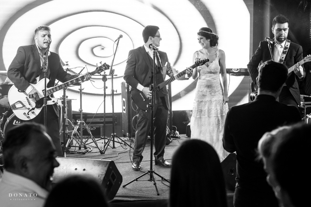noivo toca guitarra com seus amigos.