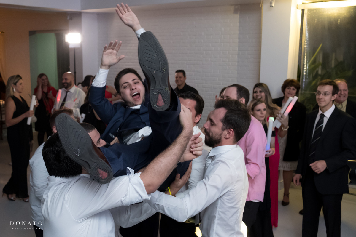 amigos jogam o noivo pra cima.