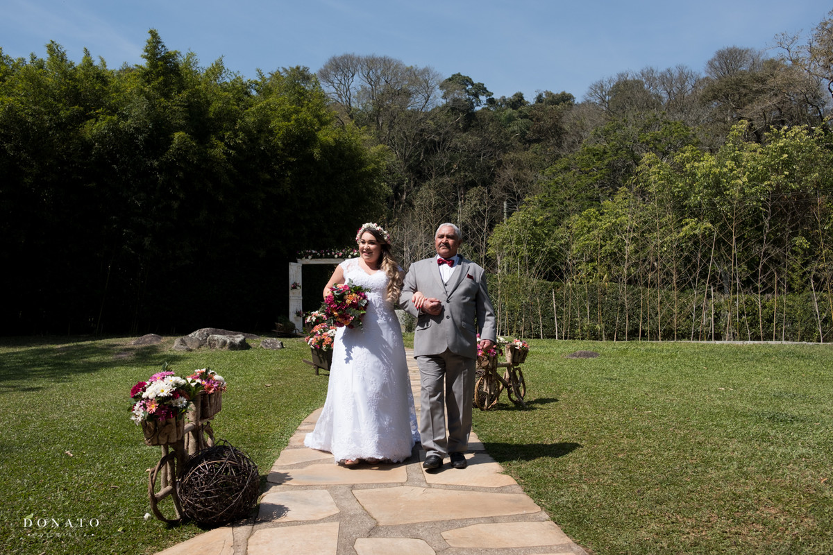 Noiva entra pelo corredor do espaço natureza.