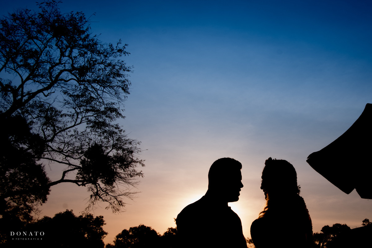 Noivos em silhueta, no espaço Natureza.