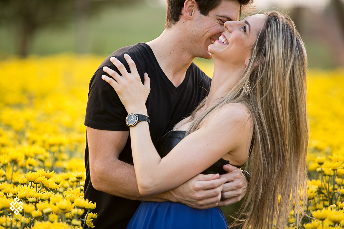 Noivos se divertem muito a frente de margaridas amarelas, a plantação gigante fica na cidade de holambra-sp.
