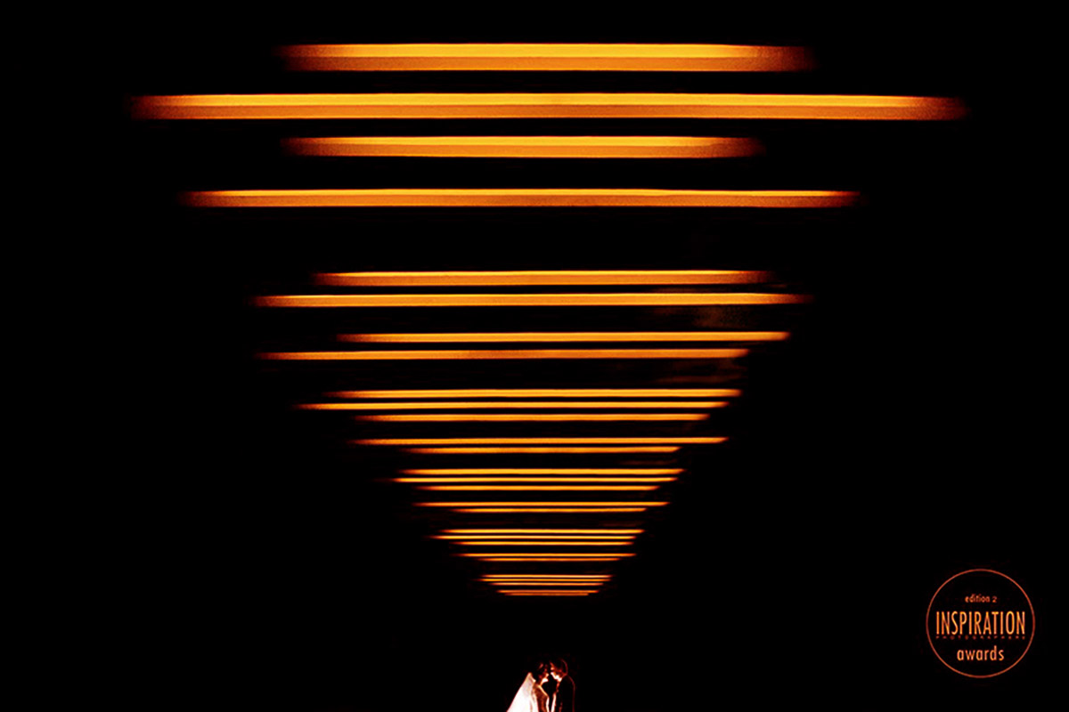 Foto de um casal minimal, linhas laranjas levam o olhar até o casal, deixando a imagem forte e criativa, foto premiada em tres concursos consecutivamente.