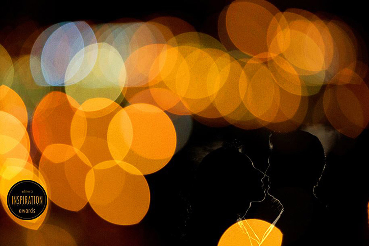 Leve contorno do casal entre uma serie de luzes laranja, a foto é muito criativa e também foi premiada algumas vezes.