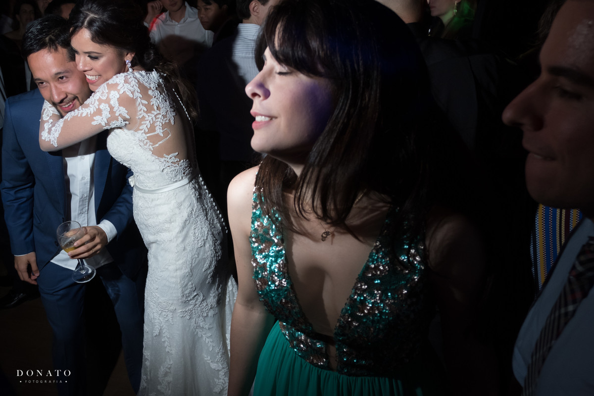 Noivos se abraçam na pista de dança.