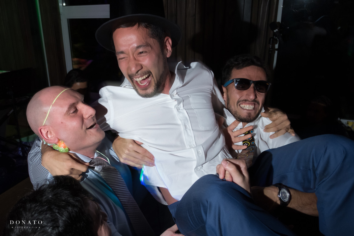 Amigos levantam o noivo no meio da balada.