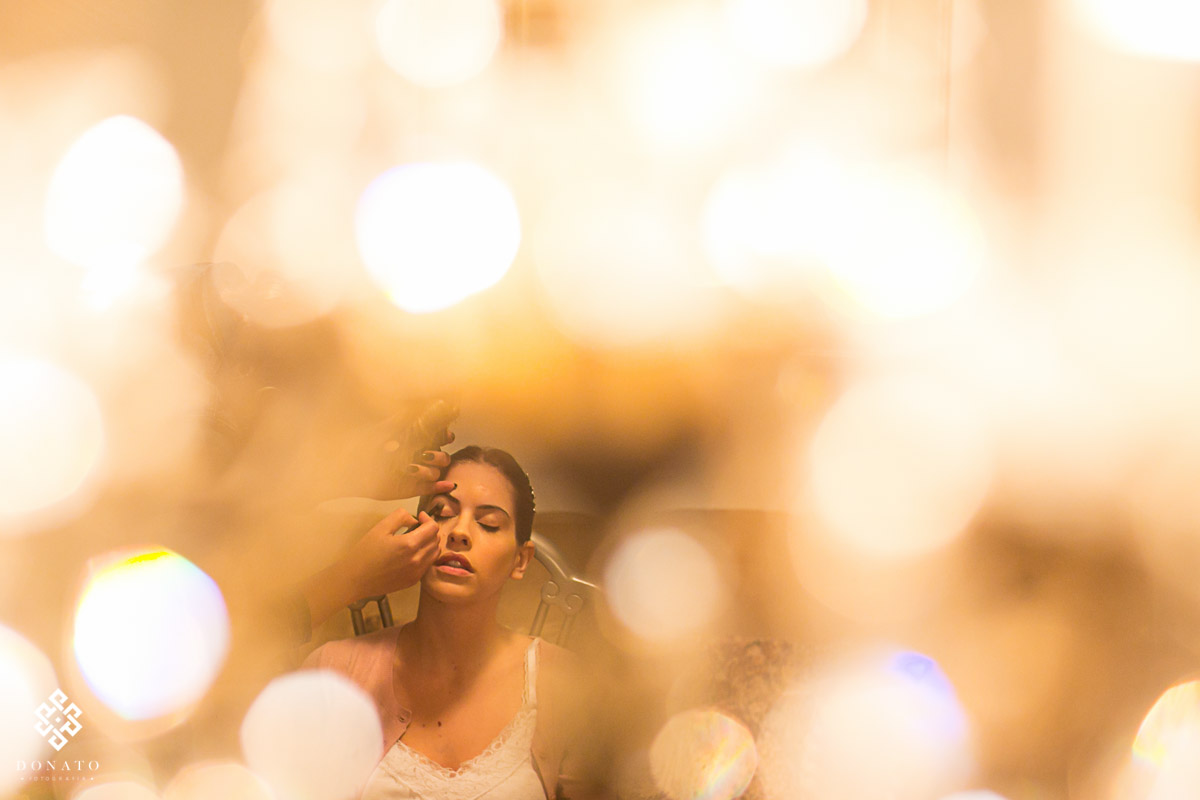 Making da noiva, imagem entre as luzes do lustre bem criativa.