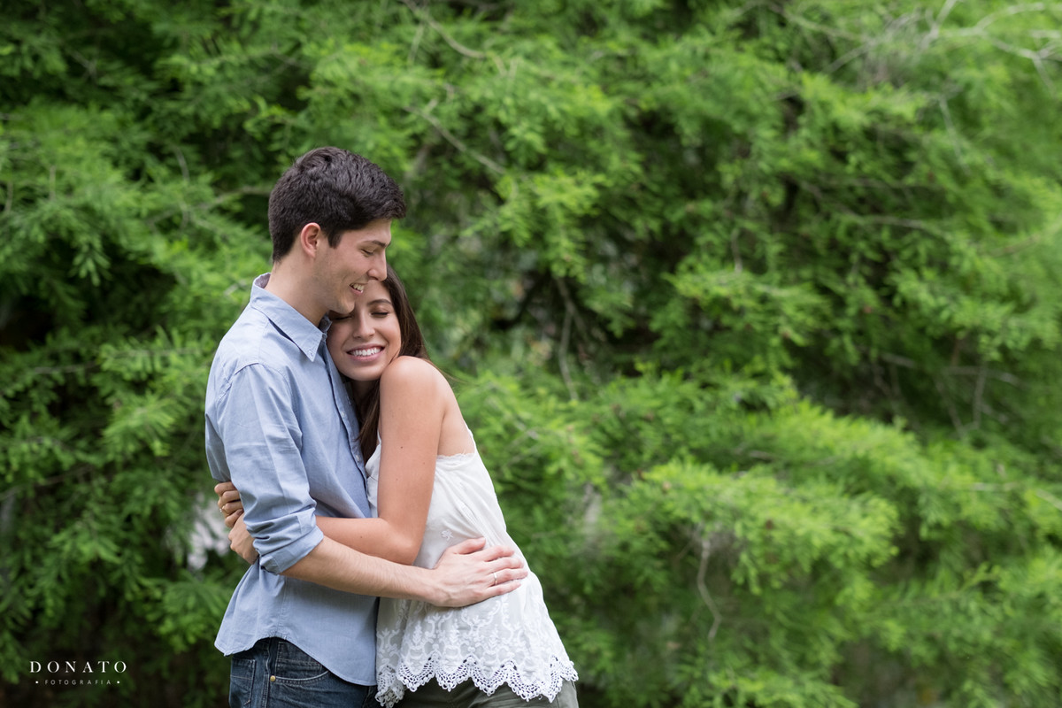 Noivos namoram entre as arvores da fazenda 7 lagoas.