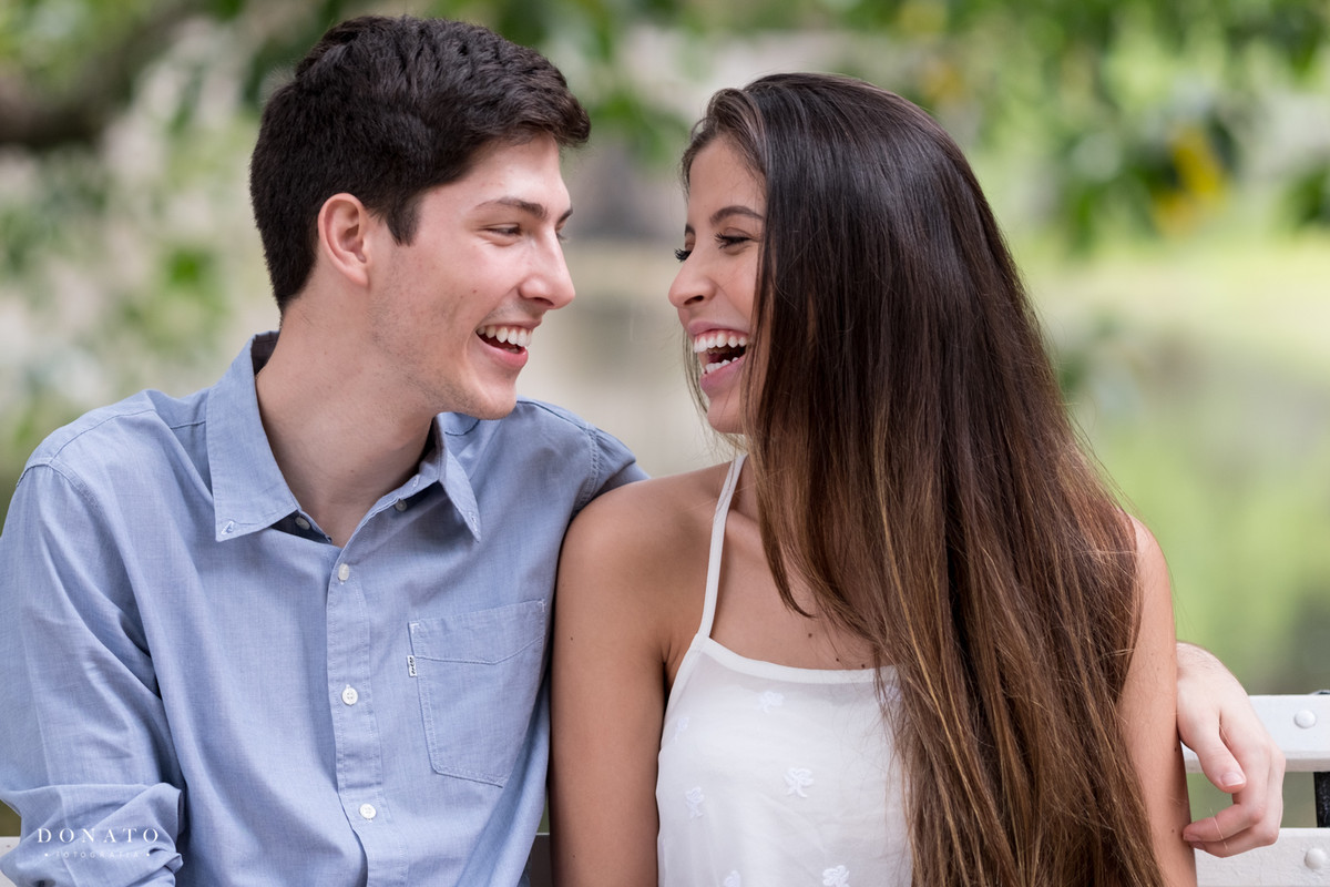 Noivos se divertem sentados em frente ao lago da fazenda 7 lagoas.