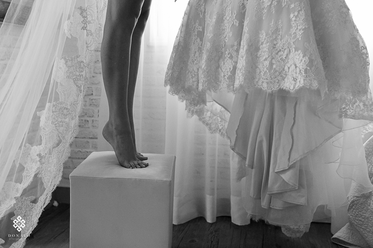 Detalhes dos pes da noiva que é bailarina, com o detalhe do pedaço do vestido, a noiva esta na ponta do pé, o que complementa a profissão dela, e devido ao corte na foto, parece que esta nua, pois so mostra as pernas e o [p&eac