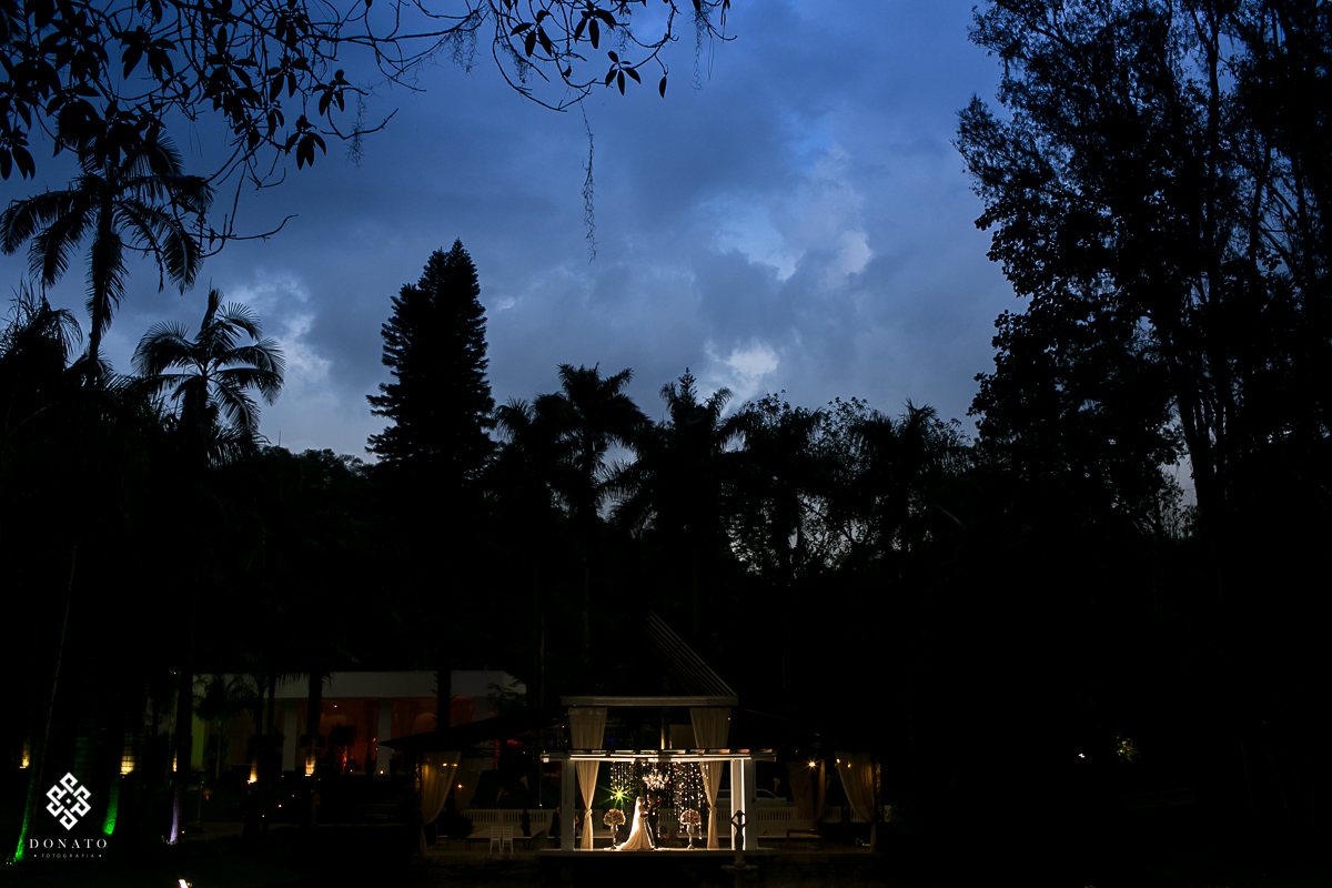 foto criativa, feita de longe mostrando todo o cenário da fazenda 7 lagoas, e com os noivos em detalhe ao meio, para completar um lindo céu azul.