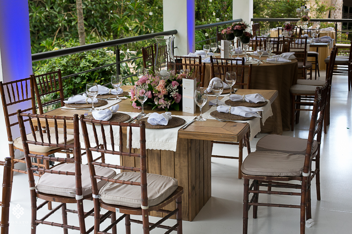 decoração com detalhes em rosa, com mesa de madeira e cadeiras que combinam, tudo isso decorando o ambiente do casamento na fazenda 7 lagoas sp.