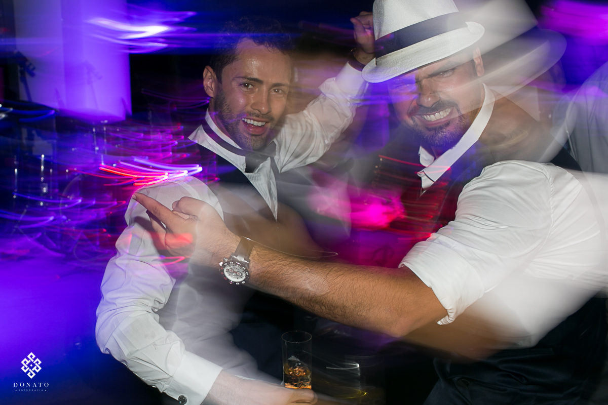 noivo e padrinho se divertem na pista, a foto é legal pois tem um moviemtno muito bacana, dando impressão de que a bebida estava rolando solta na pista.