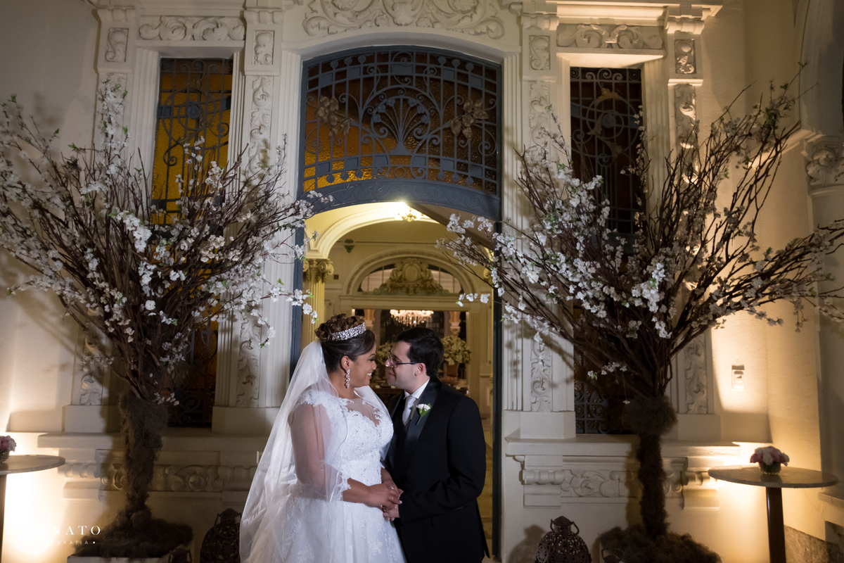 Noivos se beijam em frete ao palácio dos cedros.