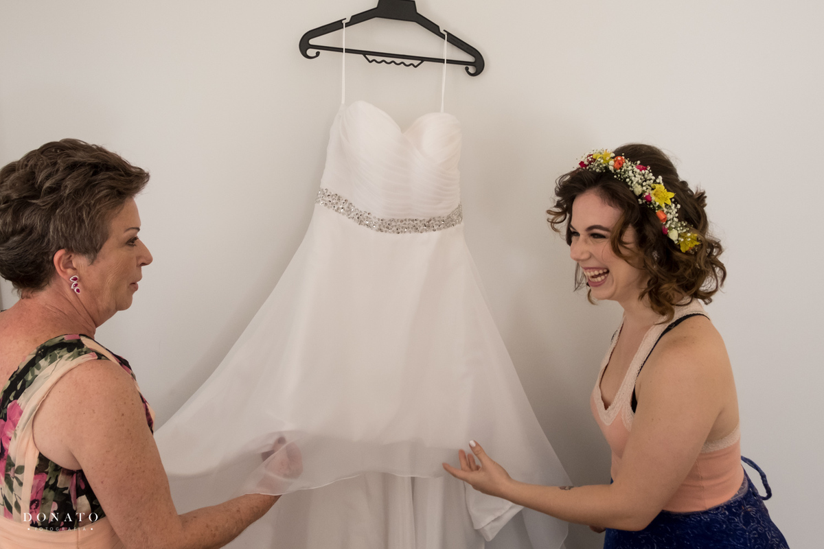Noiva e sua mãe, fechem no seu vestido lindo.