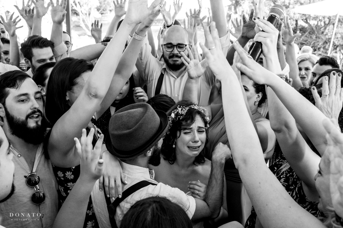 Noivos se emocionam no meio da pista de dança.