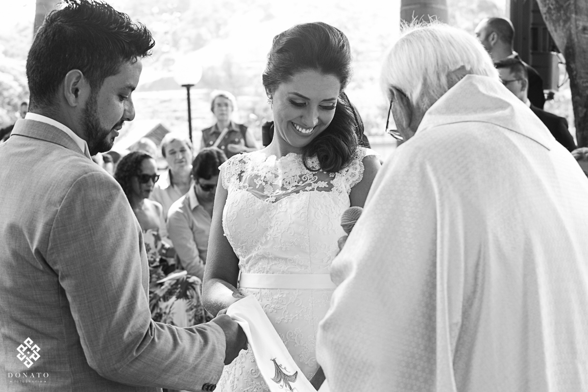 noiva sorri e olha para o padre.