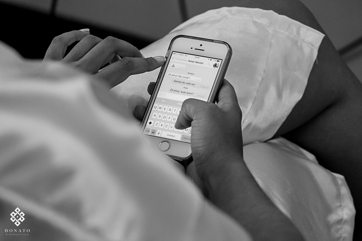 Noiva manda um recado no celular para o noivo.