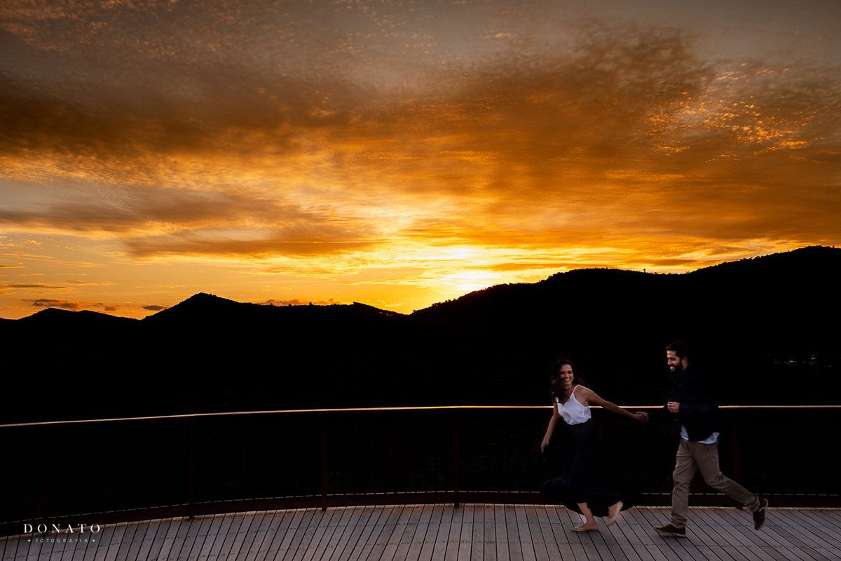 Lindo por do sol de campos do jordão, com os noivos correndo e se divertindo a frente.