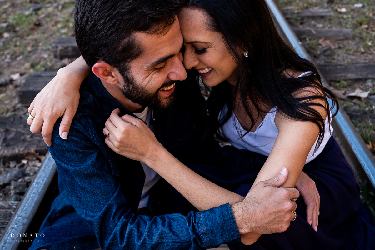 Foto do casal sentado na linha do trem de Campos do Jordão-SP