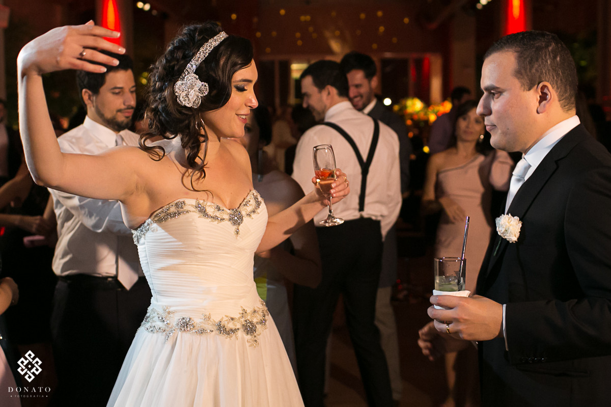 Noiva dança no salo do villa bisutti, com uma taça na mão.