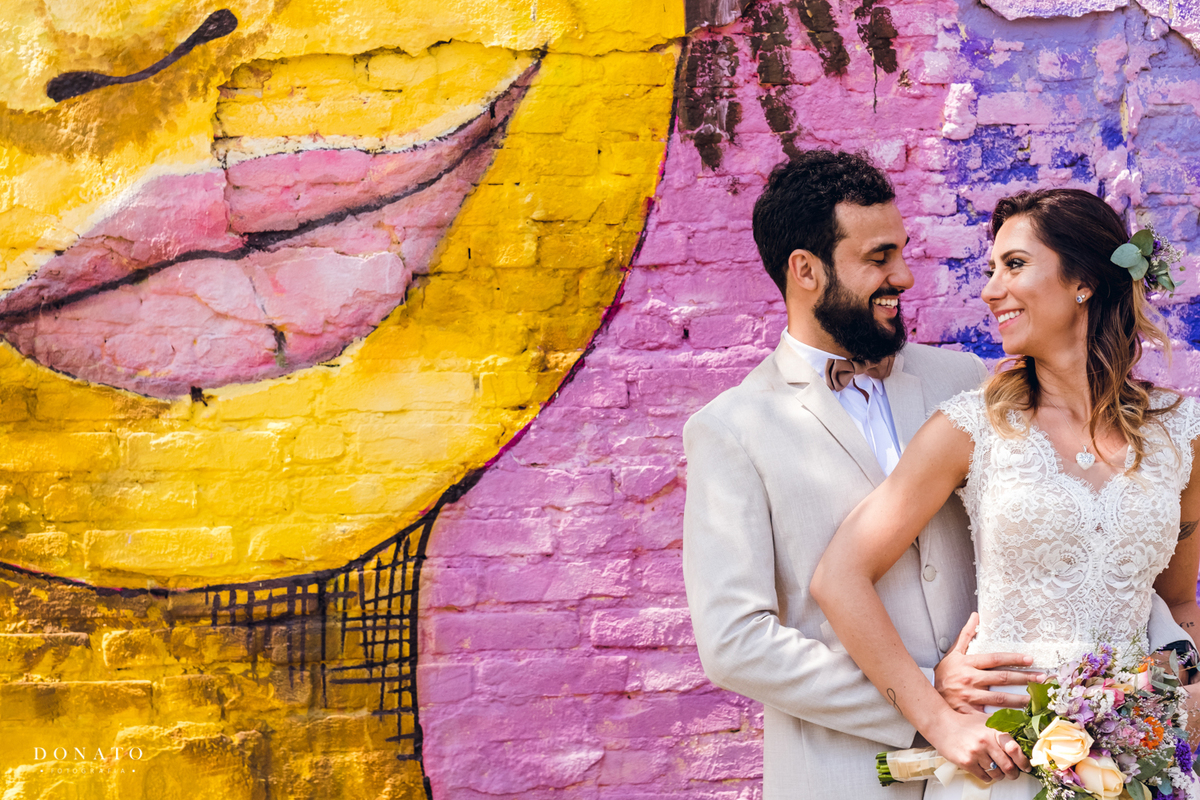 Retrato dos noivos em frente ao grafite na cidade de SP.