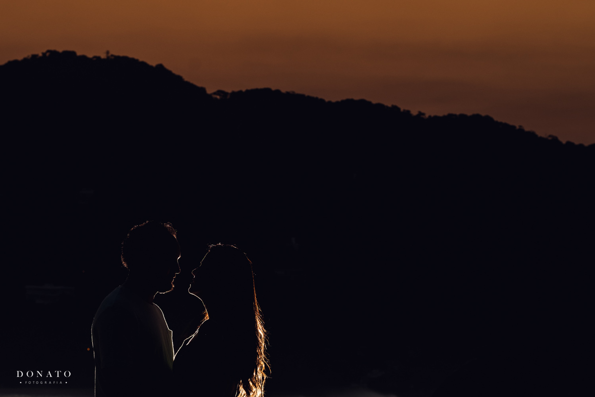 ja a noite, a foto final com os noivos no contra luz e um por do sol atras.