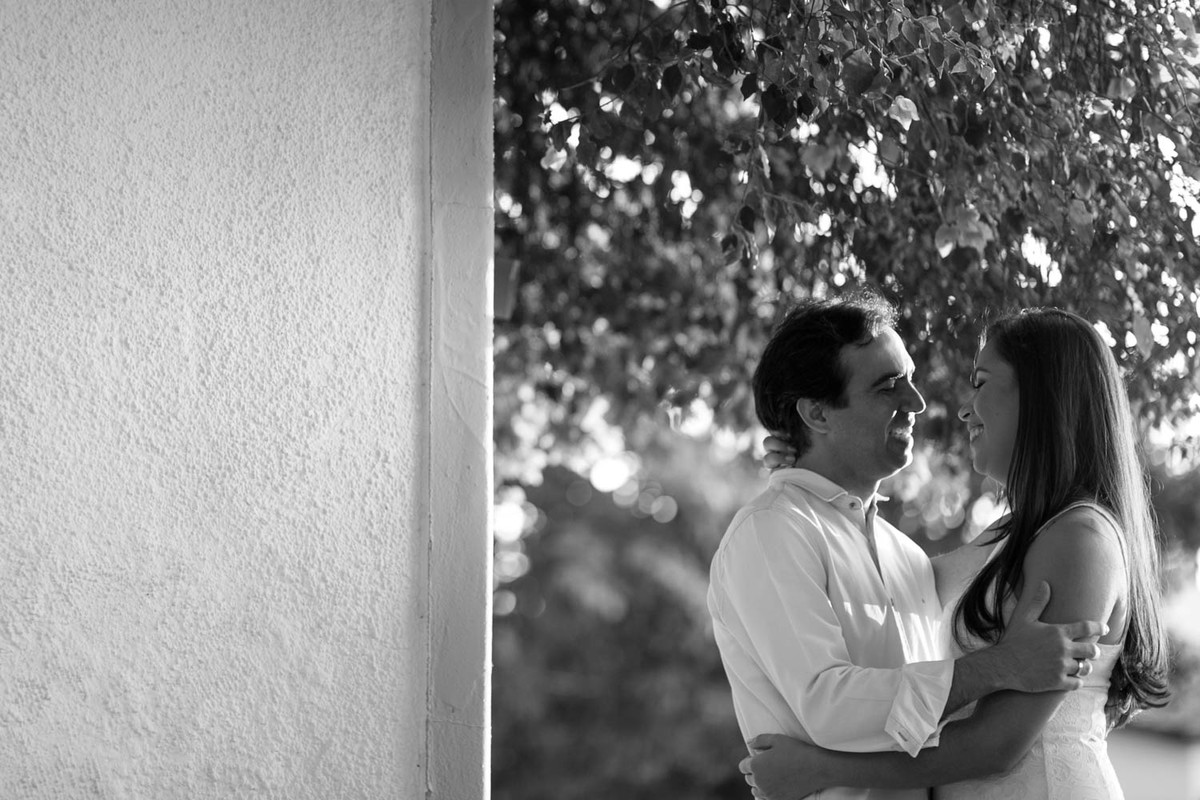 Casal se olha apaixonados, com uma linda luz contra que realça os detalhes do cabelo.