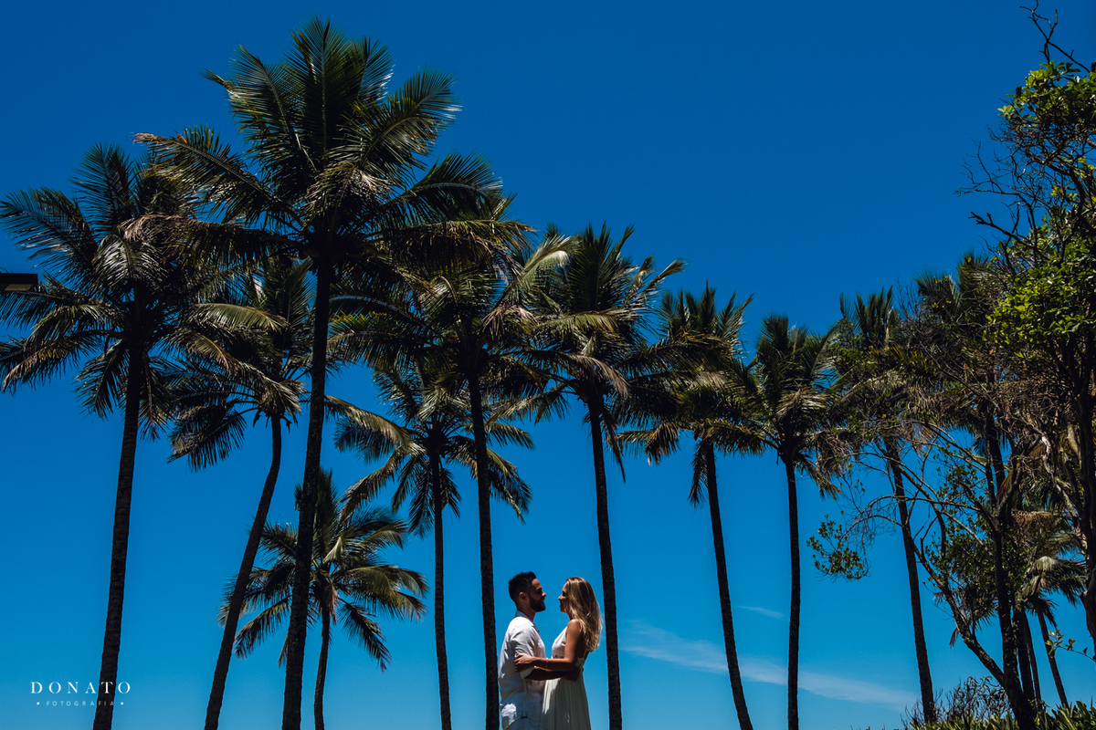 Foto dos noivos entre os coqueiros da riviera de são Lourenço-sp