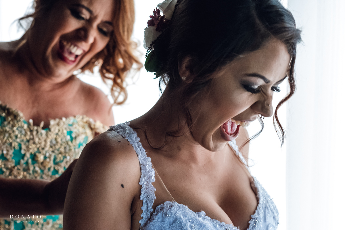 Mãe amarra o vestido da noiva.