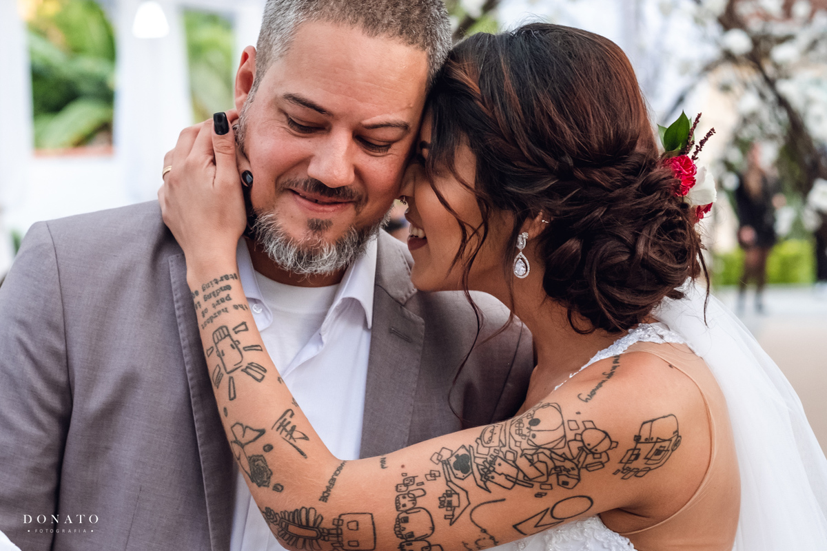 Noiva faz carinho no noivo.