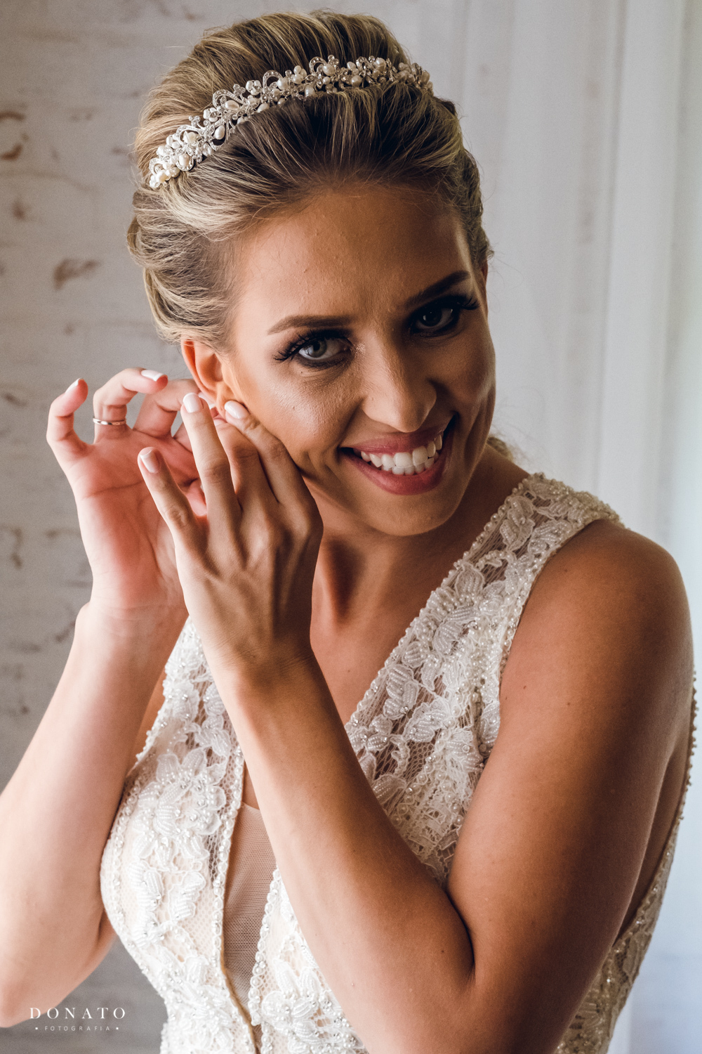 Noiva se arruma e coloca no brinco.