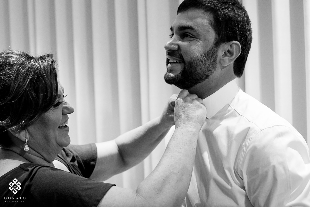 Noivo se arruma com ajuda da sua mae.