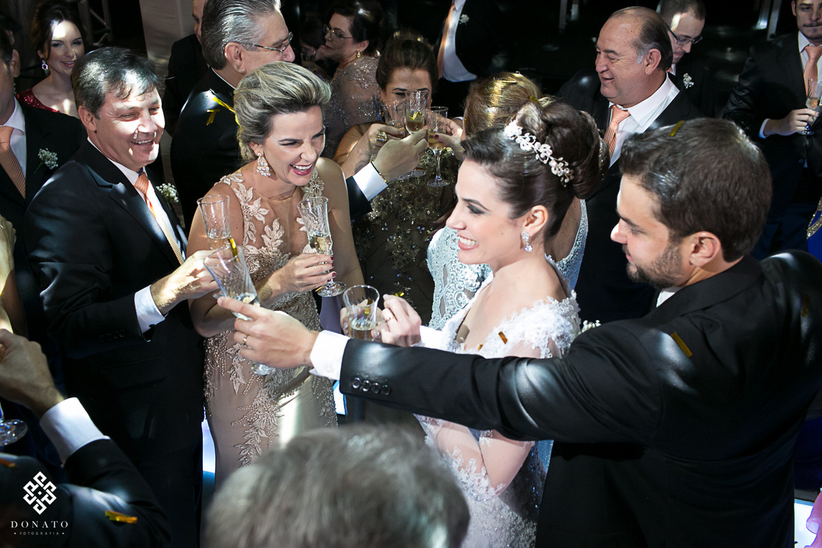 Foto do casal e padrinhos brindando, foto muito alegre e descontraída.