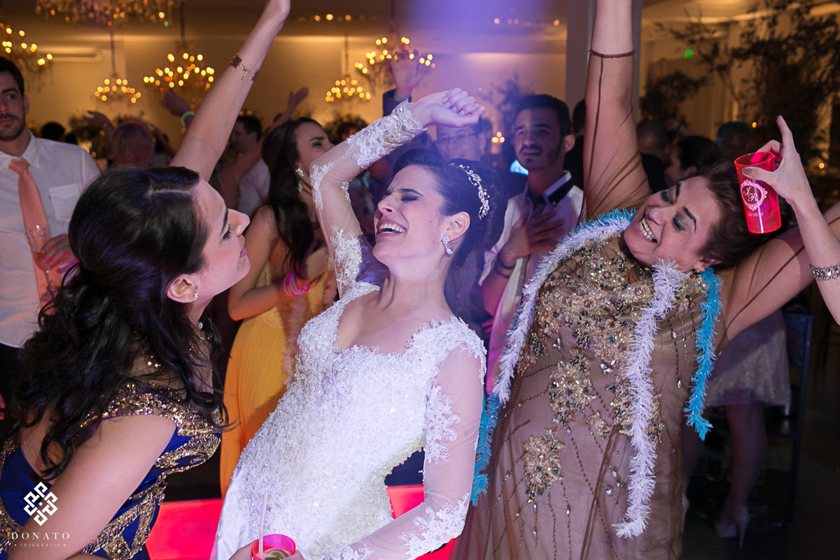 Noiva, mãe e irmã, dançam pra valer, fazendo um movimento unico e sincrionizado com o corpo para trás, muito legal ver este sincronismo na família, mesmo quando estão se divertindo.