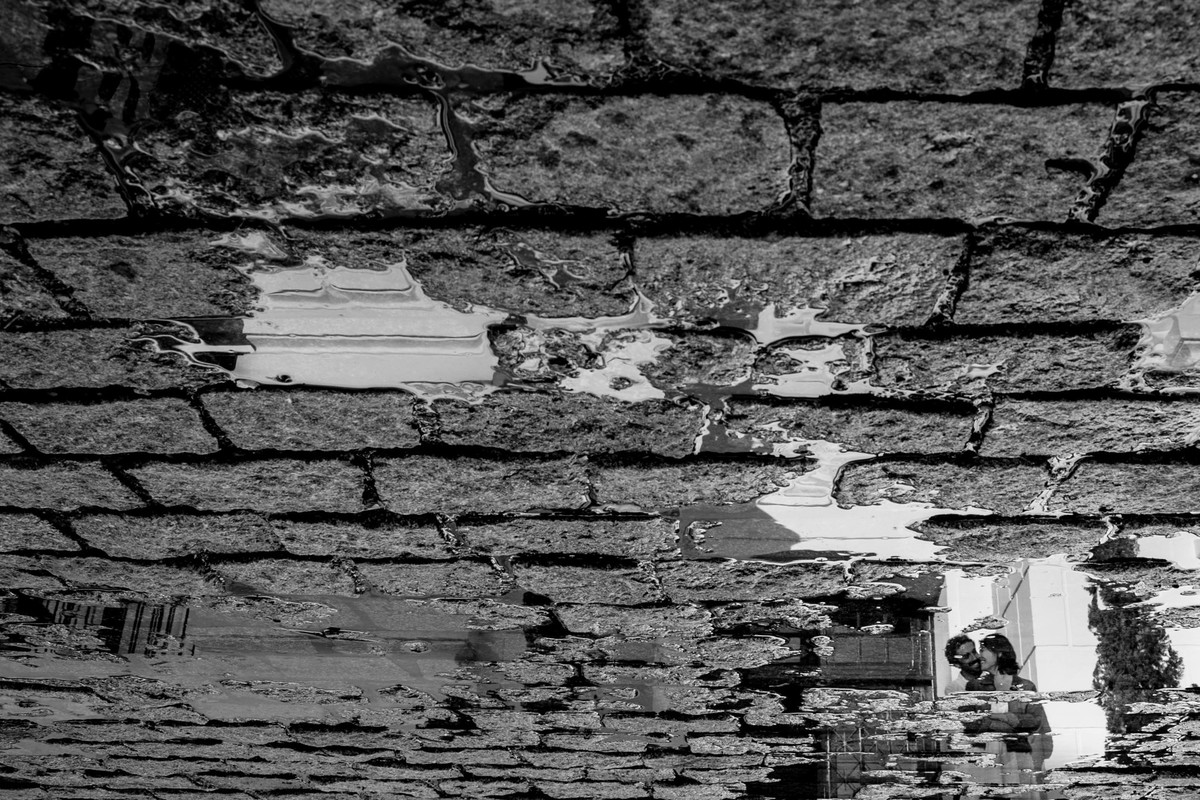 um reflexo invertido na agua, a imagem é pequena no reflexo, mas muito bonita de se ver, pois tem um fluxo que leva ate'o casal.