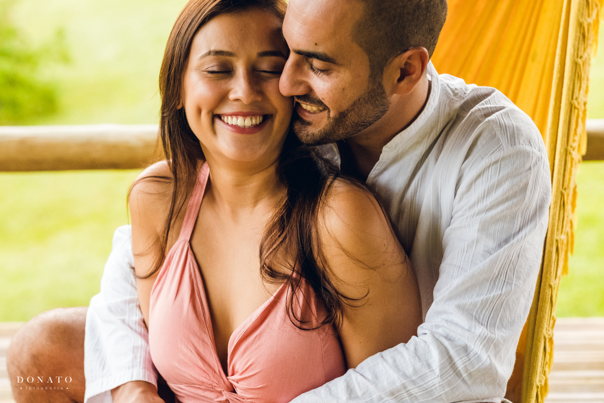 Casal namora na rede em dia chuvoso.
