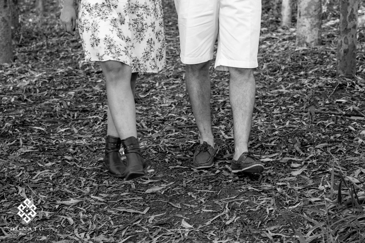 Detalhes dos pés do casal, a foto esta em preto e branco, sobre folhas de eucaliptos.