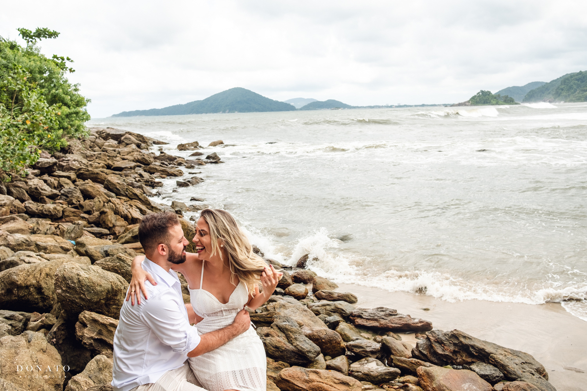 noivos se divertindo nas pedras da praia do Guarujá-sp.