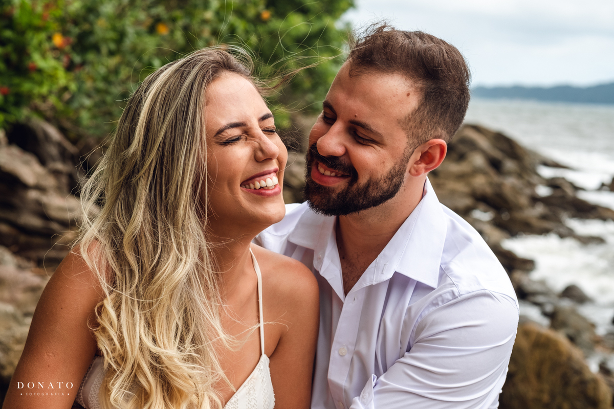 noivos se divertindo nas pedras da praia do Guarujá-sp.