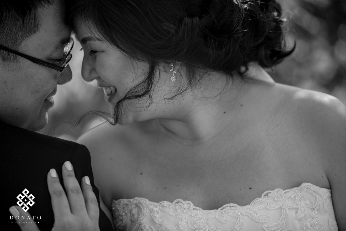 noiva namora com o noivo, a imagem é linda e romântica. O local ajuda por ser durante o dia e em meio a natureza.